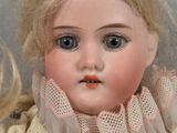 a close up of a doll with blonde hair and blue eyes