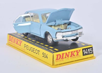 une petite voiture bleue dont le capot est ouvert, posée sur une boîte