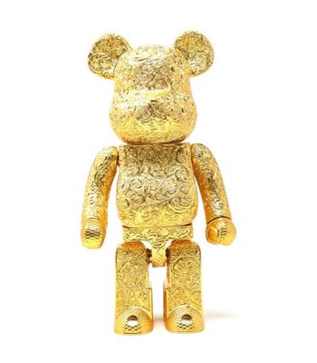 une statue d'ours en or sur fond blanc