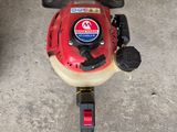 an image of a gas powered lawn mower in a garage