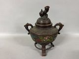 an antique bronze teapot with a bird on top