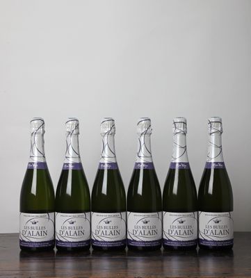 six bouteilles de vin mousseux alignées sur une table