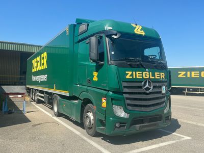 a green truck that is parked in a parking lot
