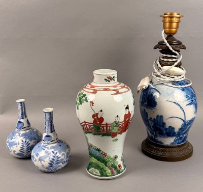 three vases and a lamp on a table with a gray background