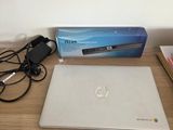 a laptop computer sitting on a desk next to a charger