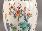 a vase with a painting on it sitting on a table
