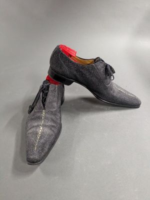 a pair of gray shoes with red laces on them
