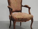 an old fashioned chair with a floral upholstered seat
