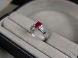 une bague sertie d'une pierre rouge, dans une boîte