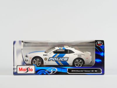 une voiture de police miniature dans une boîte, posée sur une surface blanche