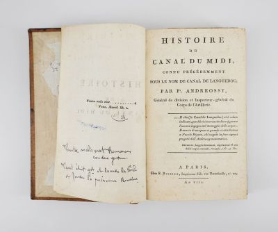 un livre ouvert avec une écriture dessus, posé sur une table