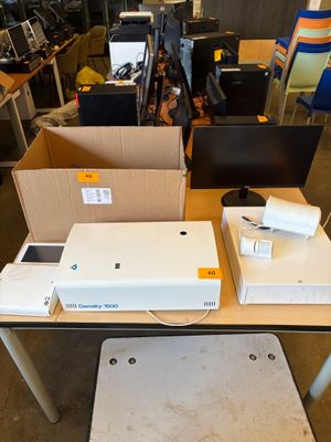 a table with a laptop, a monitor, and a printer on it