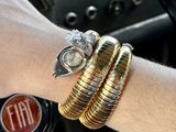 a person that is holding some gold and silver bracelets
