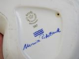 a close up of a person ' s hand holding a plate with a blue and white design on it