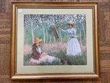 tableau encadré représentant une femme et un chien dans un jardin