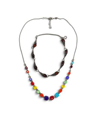 un gros plan d'un collier et d'un bracelet sur fond blanc