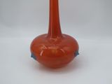 a red vase that is sitting on a white table