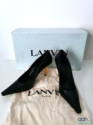 a pair of black shoes sitting on top of a white bag
