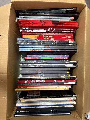 une boîte en carton remplie de DVD posée par terre