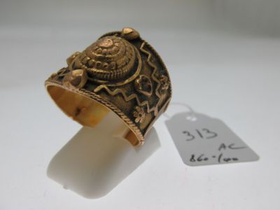 an image of a gold ring on a white surface with a price tag
