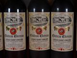 several bottles of red wine are lined up on a shelf