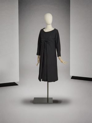 une photo d'un mannequin portant une robe noire dans une pièce blanche
