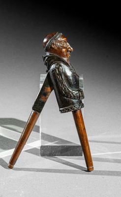une statue représentant un homme avec une canne, posée sur une table