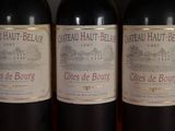 three bottles of red wine are lined up on a table