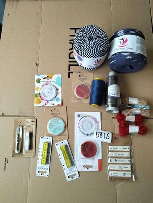 a box with a bunch of sewing supplies sitting on top of it