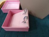 two pink boxes with rings in them sitting on a blue carpet