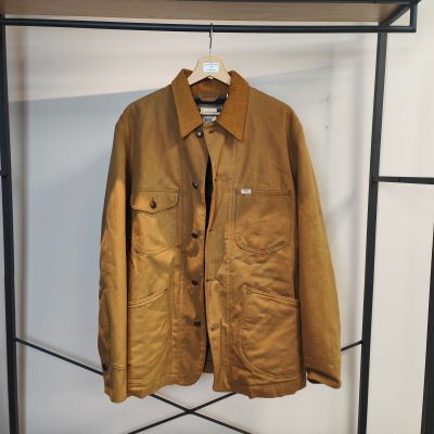 une veste marron accrochée à un porte-manteau dans une pièce