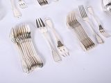many forks and spoons laid out on a table