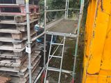 une échelle posée à côté d'une pile de palettes