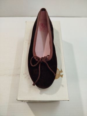 quelqu'un porte une paire de chaussures posées sur une boîte