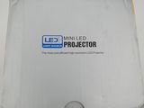 an open box of a projector sitting on top of a white table