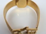 an image of a gold watch on a white surface