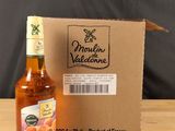 une bouteille de vin de pêche posée à côté d'un carton sur une table en bois