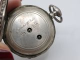 a person holding a silver pocket watch in their hand