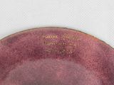 a purple plate with writing on it sitting on a table