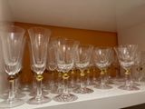 de nombreux verres à vin alignés sur une étagère dans une pièce