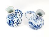 two blue and white vases sitting next to each other