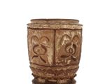 une tasse marron posée sur une surface blanche