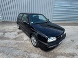 La voiture noire est garée devant un garage.