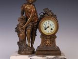 une statue représentant un garçon avec une horloge, posée sur un socle en marbre