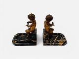 paire de figurines anciennes en bronze représentant un garçon et une fille, sur des socles en marbre
