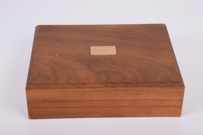 une petite boîte en bois avec une étiquette marron dessus