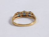 a close up of a gold ring with blue stones on it
