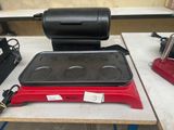 une photo d'une plaque de cuisson électrique rouge et noire posée sur une table