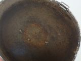 a person holding a dirty pan on a table