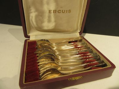 silverware in a case with red velvet lining on a white table